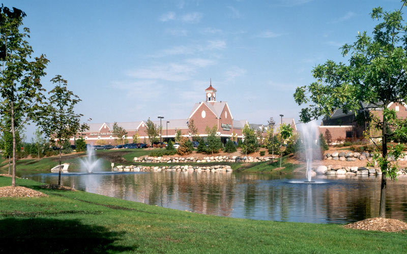 Photo of Frontline Facility Partners tended landscaping with a lake, lawn, trees, flowers, and hedges for Grand Sakwa